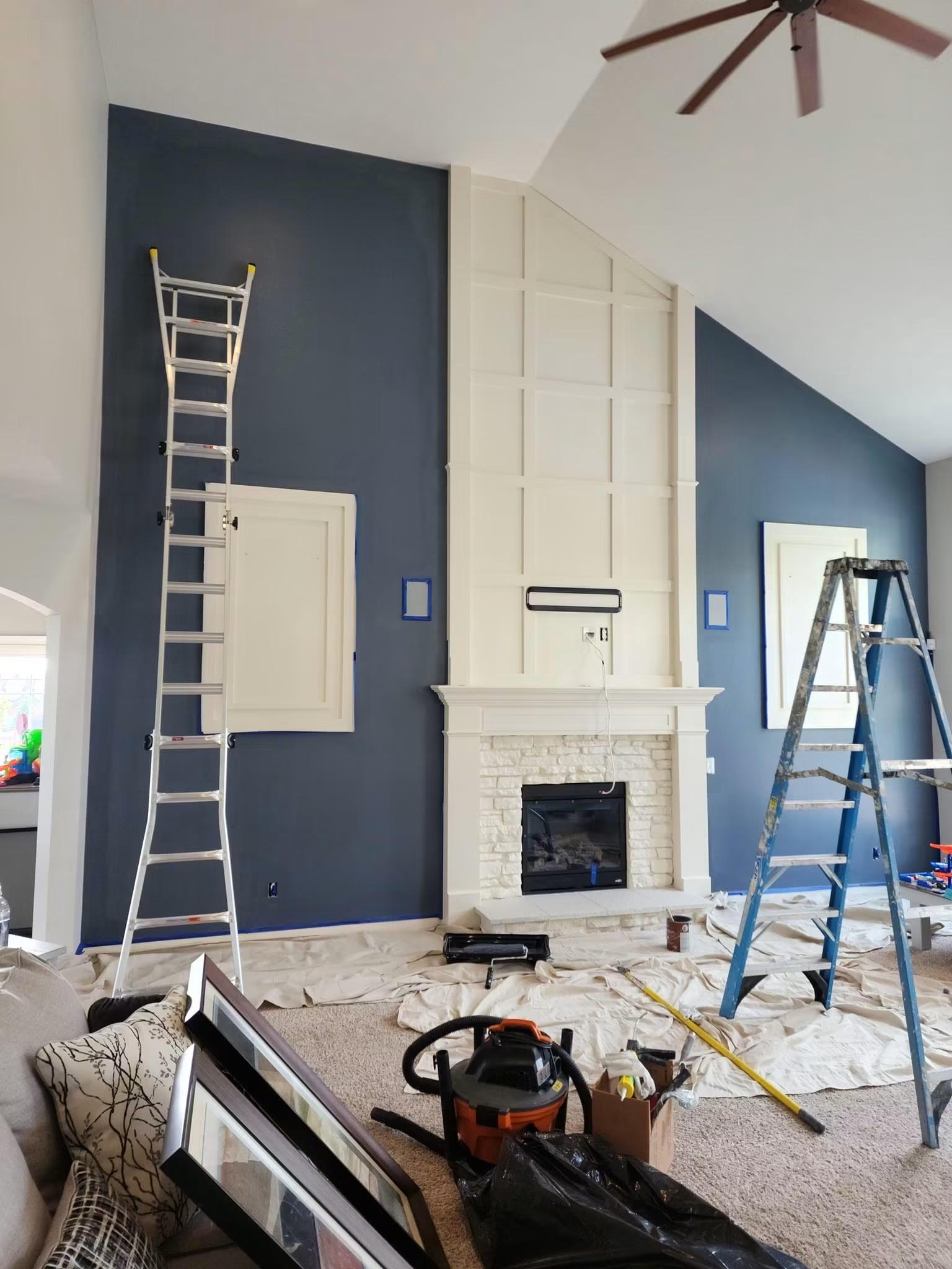 Living room with a deep blue accent wall and a painted white fireplace surround